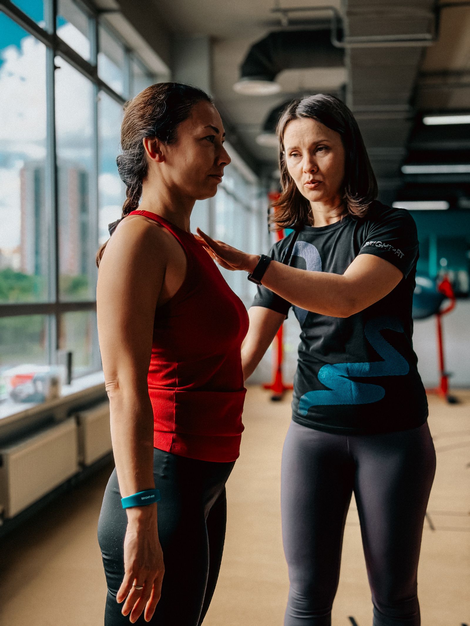 Personal trainer guiding a student at the gym